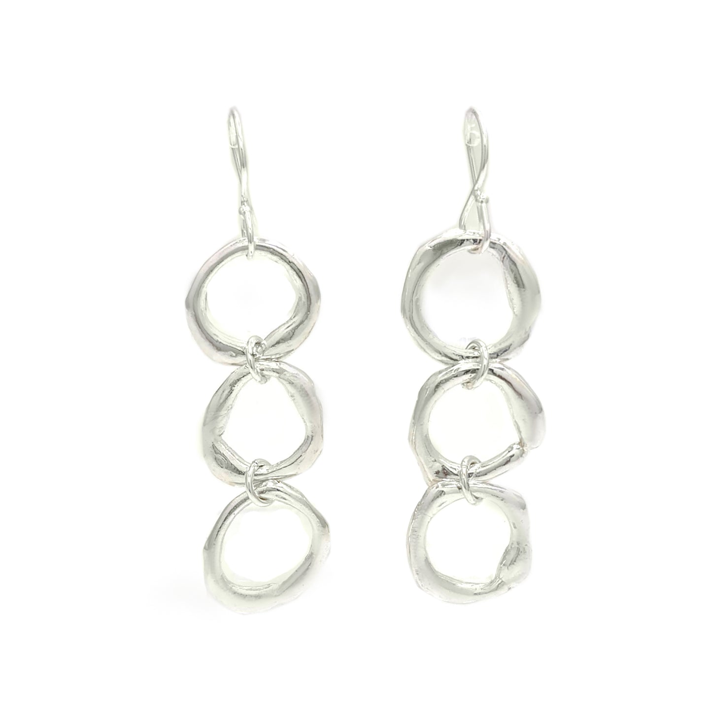 Introducing the "Join Together Earrings" by FR | Art Jewellery: a pair of elegant dangle earrings featuring three interlocking, irregularly shaped silver rings. Handmade with precision, these rings are linked vertically to create a fluid and contemporary design. The earrings also come with simple hook fastenings at the top for easy wear.