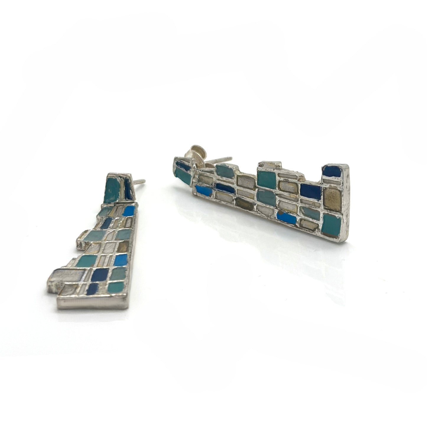 The Klimt Earrings by FR | Art Jewellery feature geometric building-inspired shapes in enamel-painted sterling silver, with blue, turquoise, gold, and white inlays. Displayed on a white background.