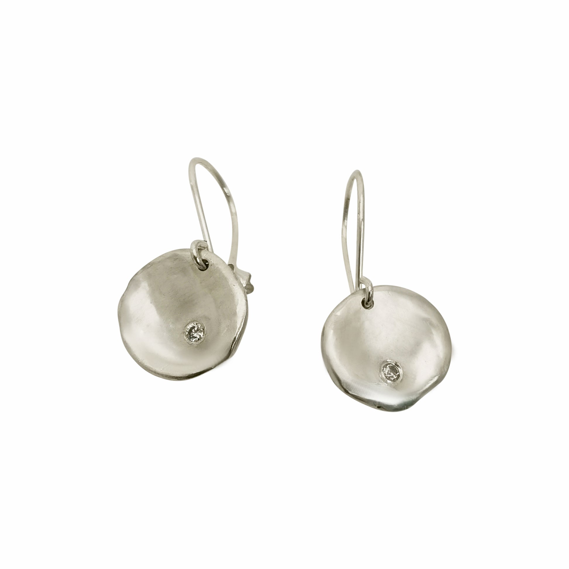 A pair of elegant Full Moon Earrings by FR | Art Jewellery, each featuring a small, round diamond set in the center. The gold discs have a slightly irregular, organic shape, giving them a unique and artisanal appearance. These handmade jewellery pieces are attached to slim hooks for wearing.