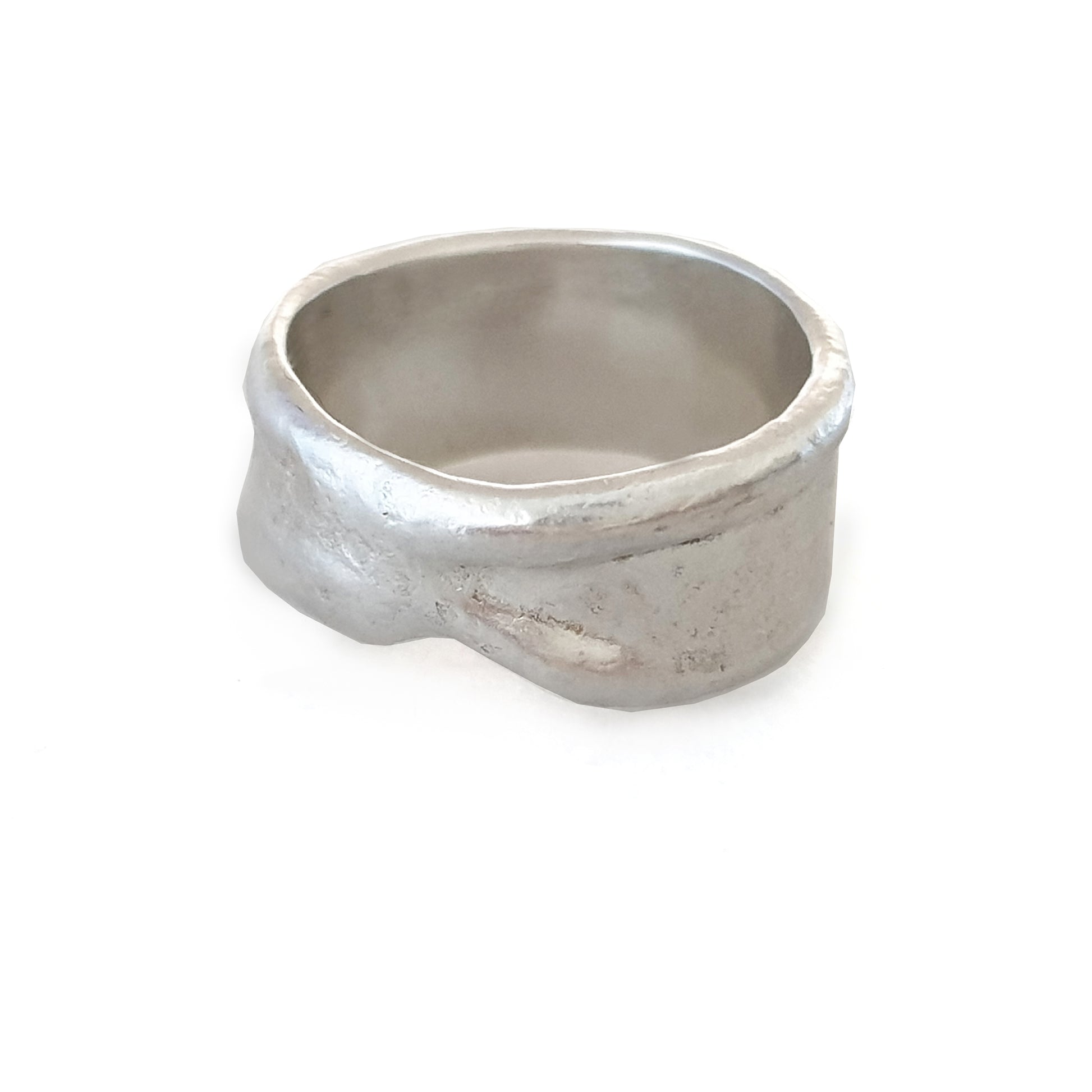 The Melted Ring by FR | Art Jewellery, featuring a rugged, textured surface and a slightly irregular, wide band, sits against a white background. The matte finish of the silver ring enhances its unique, handcrafted design characteristic of Handmade Jewellery.