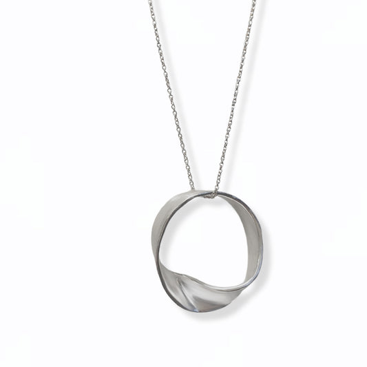 Introducing the MoeBius Band Necklace by FR | Art Jewellery: a minimalist silver necklace showcasing a twisted, flat circular pendant suspended from a delicate silver chain. This piece of handmade jewellery boasts a sleek, modern design with a continuous loop that appears gently twisted. Available for custom-made orders, all set against a plain white background.