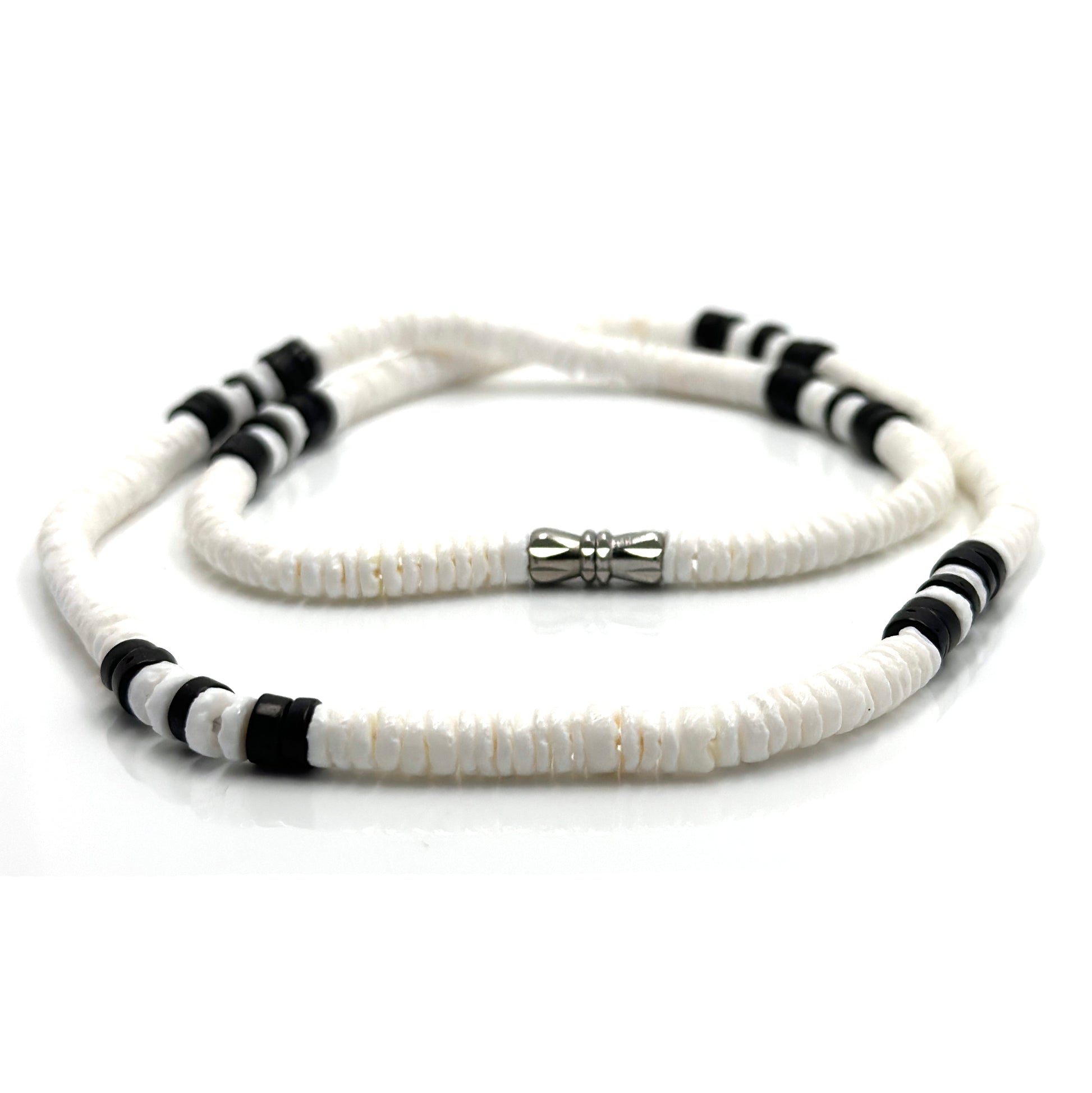 The White and Black Beaded Necklace by FR | Art Jewellery (Thamus Design) features monochrome shell beads with black accents and a silver cylindrical clasp, shown coiled on a white background.