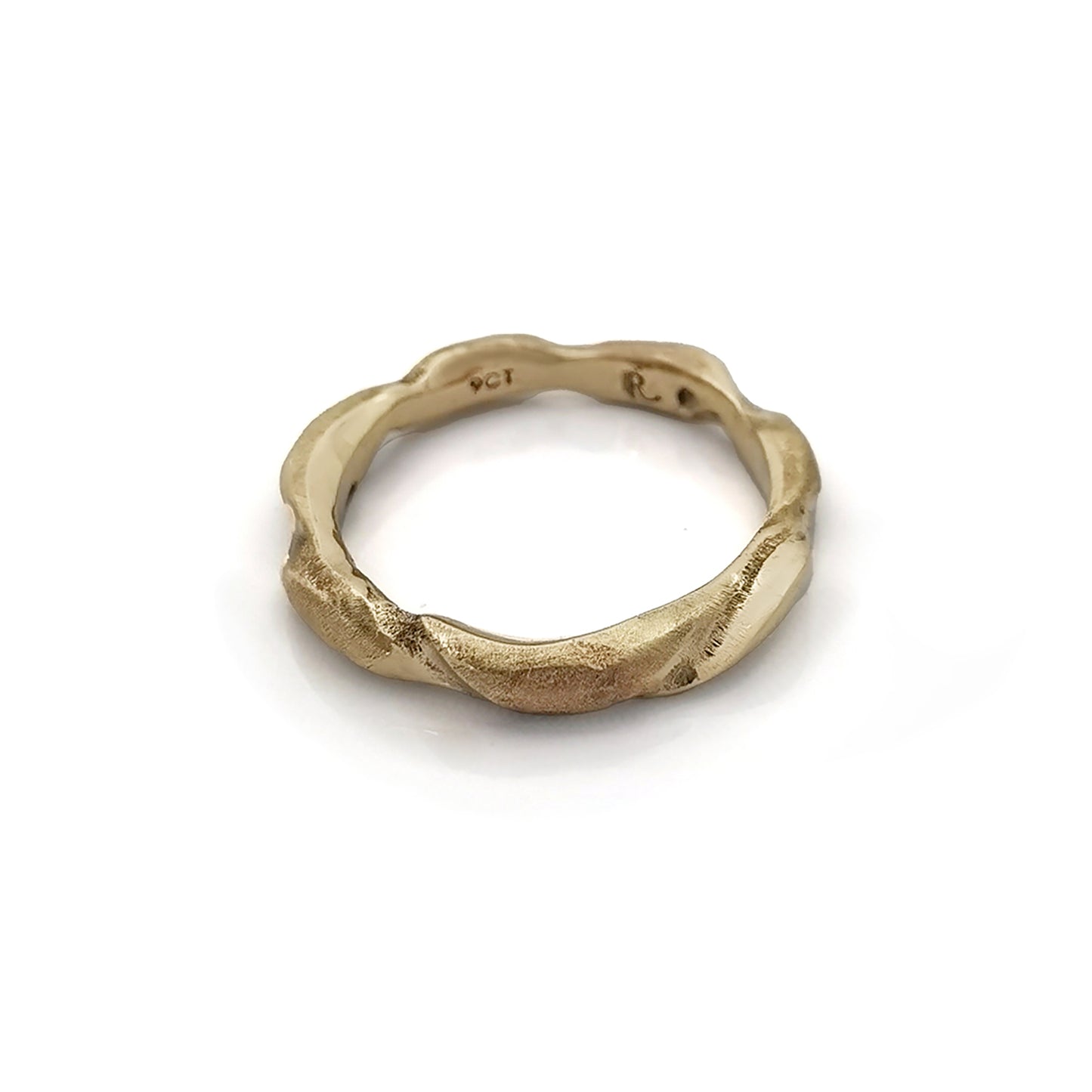 The Ocean Band by FR | Art Jewellery is a gold ring featuring a distinctive wavy texture that wraps around the band. With its polished finish and handcrafted appearance, the ring exudes an organic and artistic vibe. Subtle engravings adorn the inside of the band. This exquisite piece of handmade jewellery is showcased against a white background.
