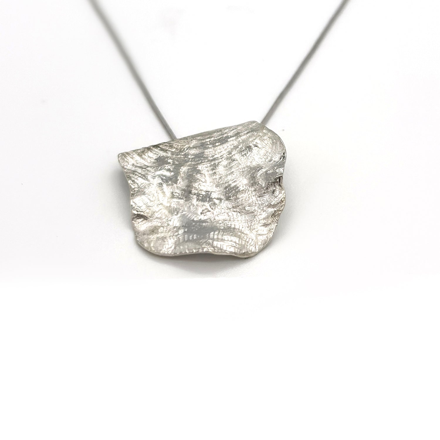 Handmade sterling silver organic pendant necklace with sculptural textured surface by FR Art Jewellery.