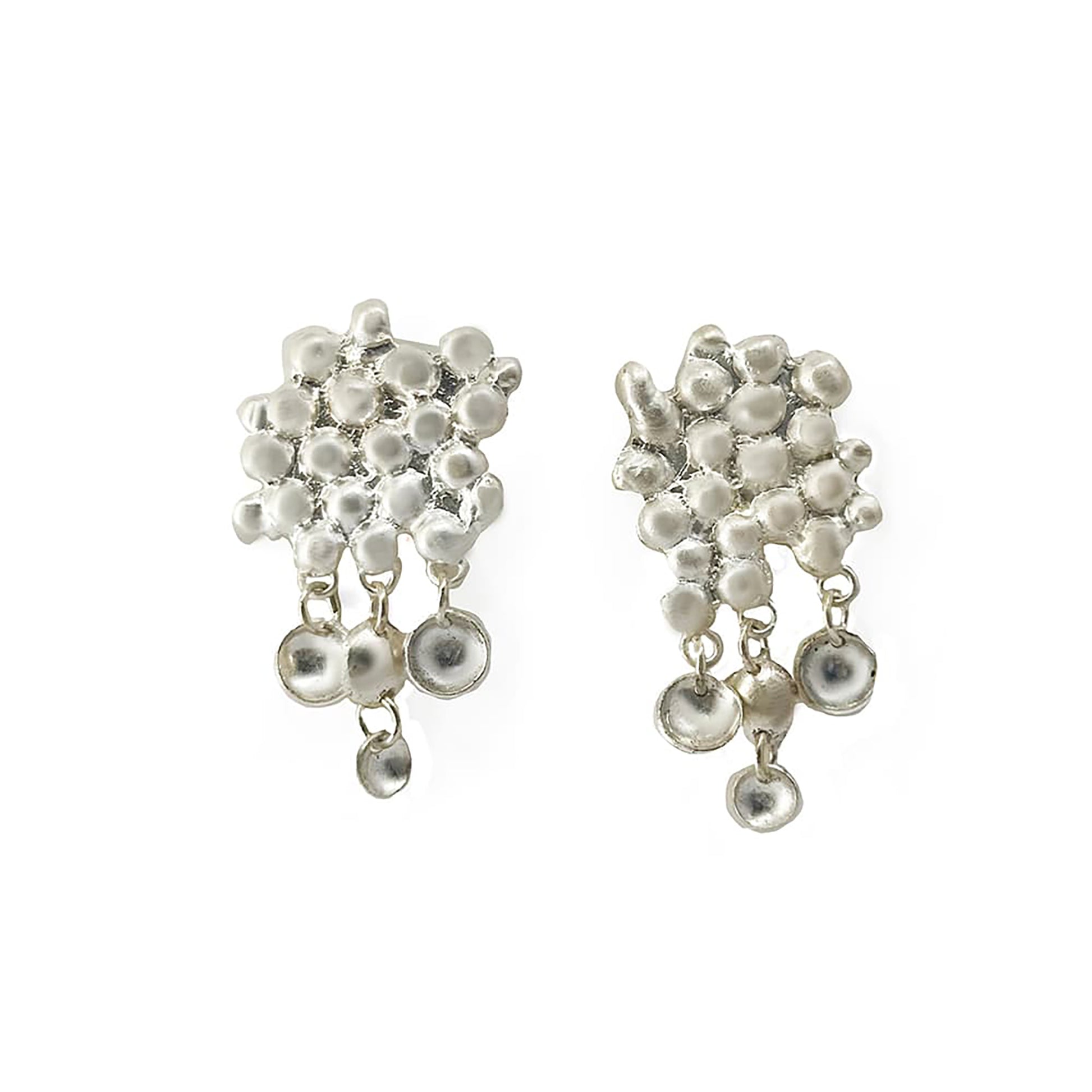 Introducing the Perlas Performing Earrings from FR | Art Jewellery: a stunning pair of sterling silver earrings featuring an abstract, clustered design with variously sized circular elements. These earrings boast a mix of solid and hollow circles, creating a textured and multifaceted look. With some circles dangling from the main structure, they perfectly highlight the charm of handmade jewellery.