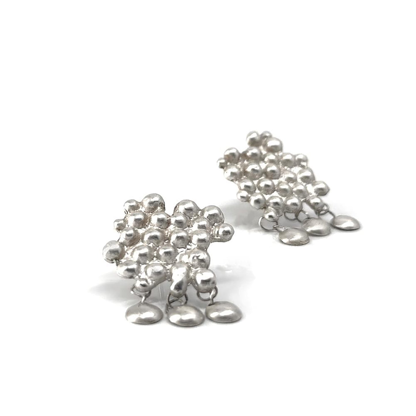 A pair of FR | Art Jewellery’s Perlas Dancing Earrings, made of sterling silver and designed with a cluster of small beads in a floral pattern, each adorned with three larger teardrop-shaped beads dangling gracefully. They are showcased against a plain white background.