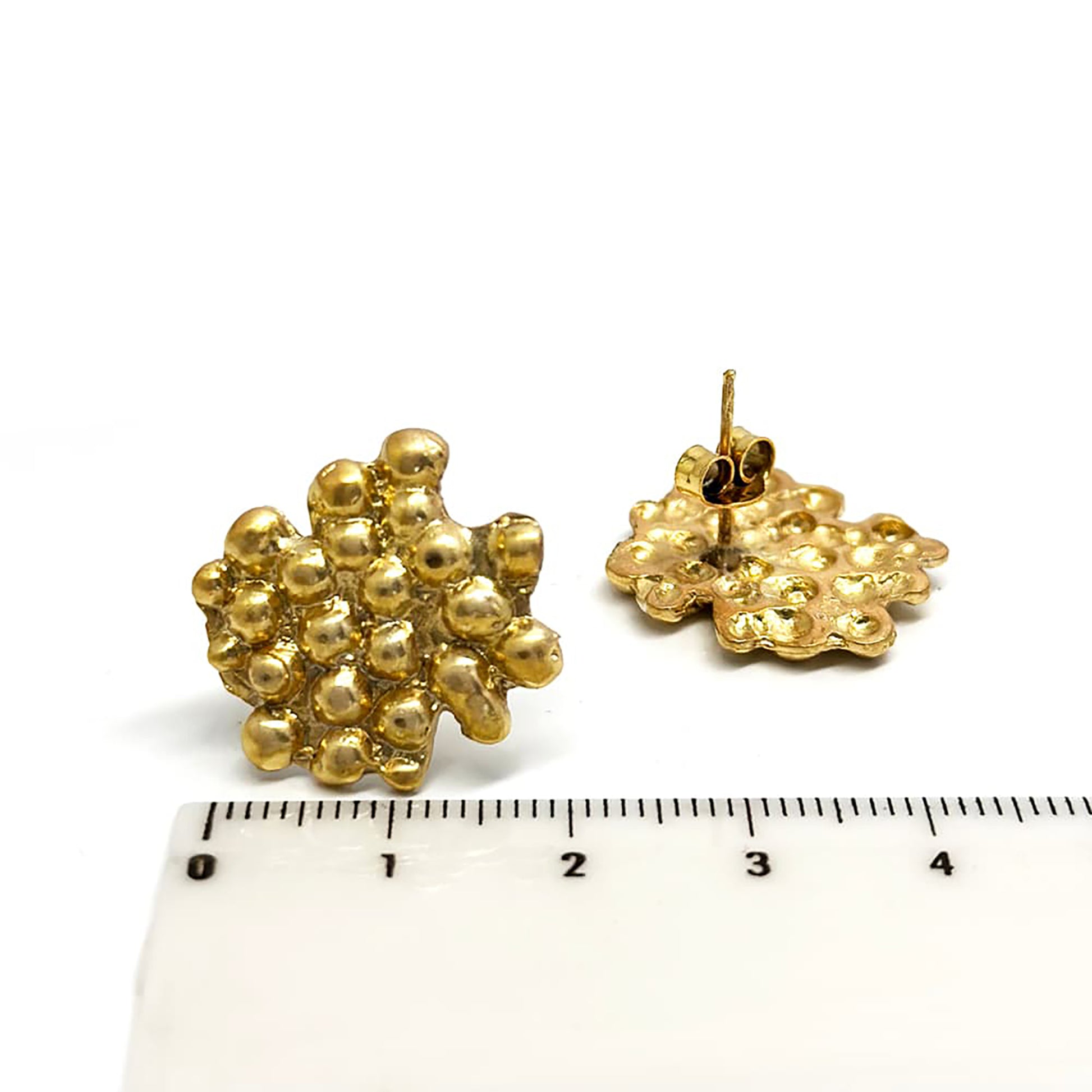 A pair of gold nugget-shaped Perlas Earrings from the FR | Art Jewellery Bondi to Bronte Collection, featuring a textured, uneven surface. The earrings are displayed on a white background, one lying down to show the backing and the other standing upright.