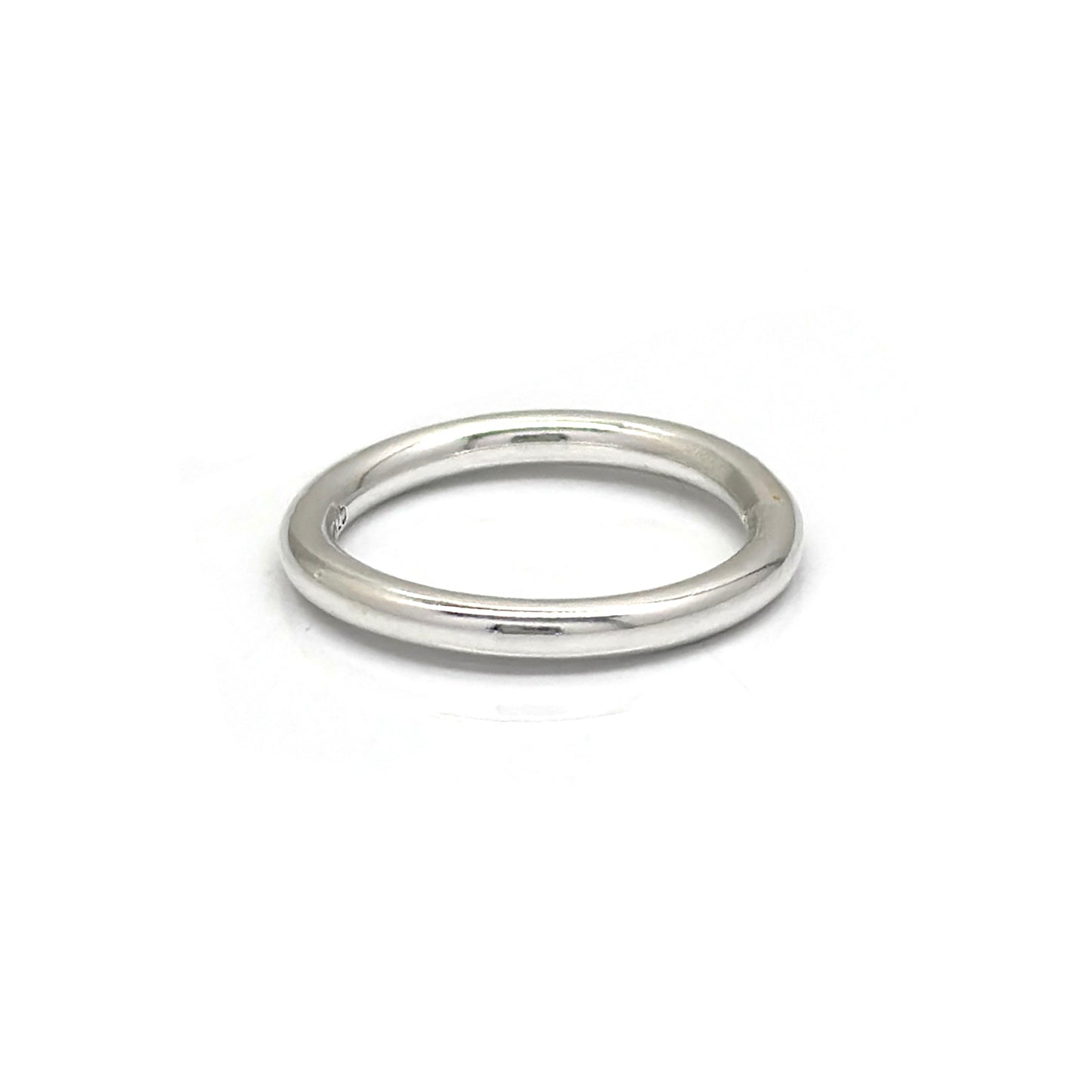 The Round Ring by FR | Art Jewellery is a simple, sleek silver wedding band featuring a smooth, polished finish. Its classic, timeless design boasts a rounded band without any additional embellishments or decorations. This handmade piece of jewellery is displayed against a plain white background.