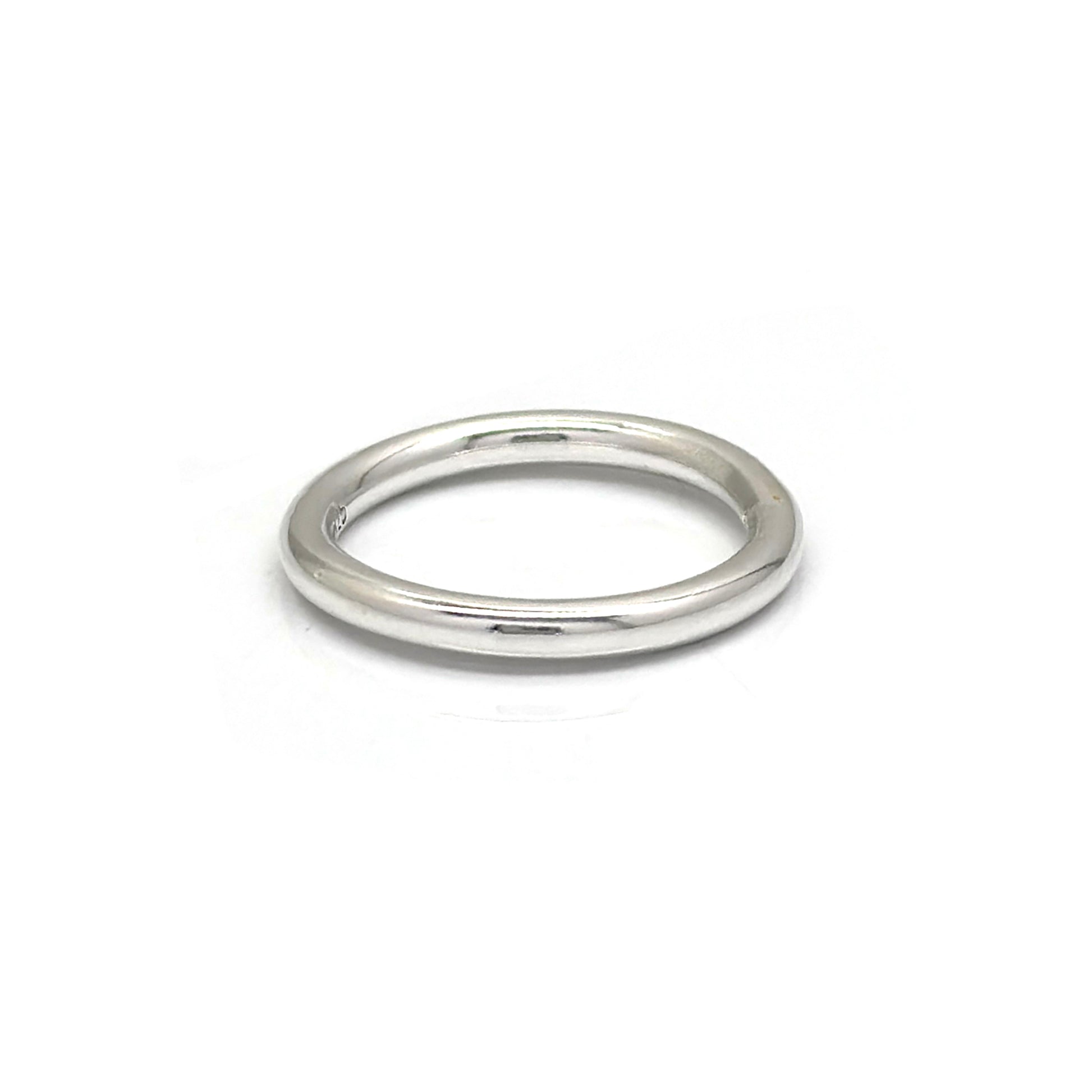 The Round Ring by FR | Art Jewellery is a simple, sleek silver wedding band featuring a smooth, polished finish. Its classic, timeless design boasts a rounded band without any additional embellishments or decorations. This handmade piece of jewellery is displayed against a plain white background.