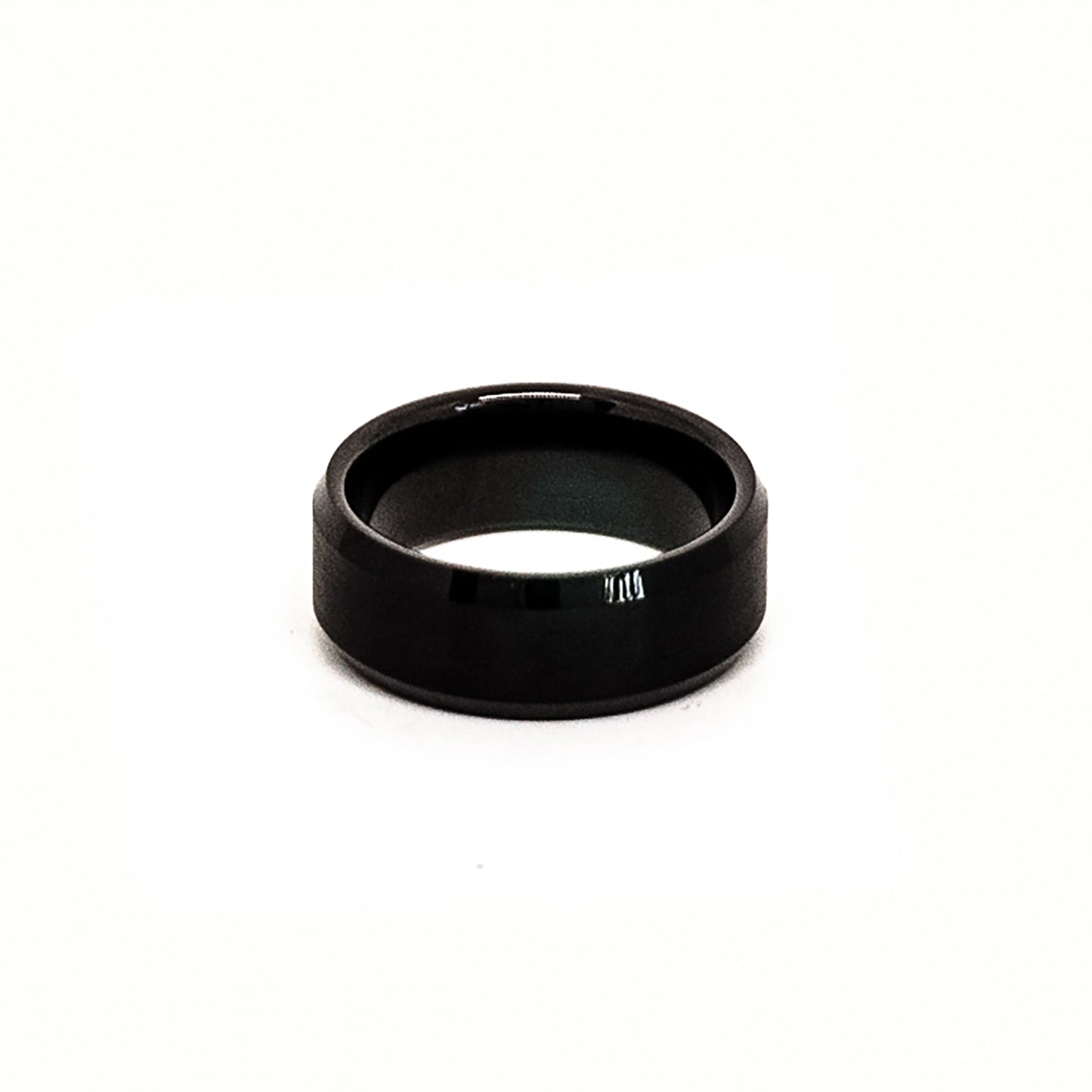 The Stainless Steel Black Bezel ring by FR | Art Jewellery, featuring a glossy, polished finish, stands upright against a white background.