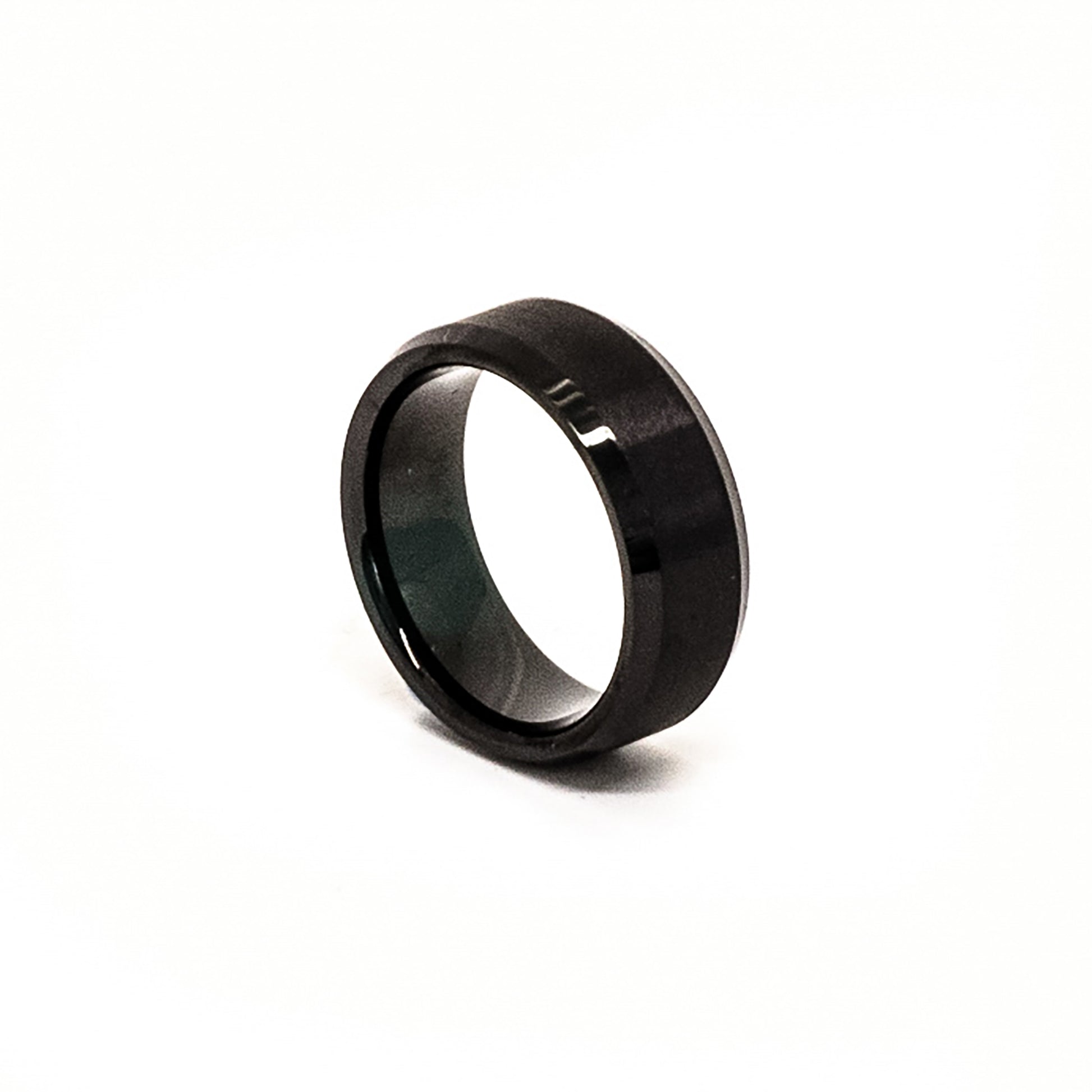 The Stainless Steel Black Bezel ring by FR | Art Jewellery, featuring a glossy, polished finish, stands upright against a white background.