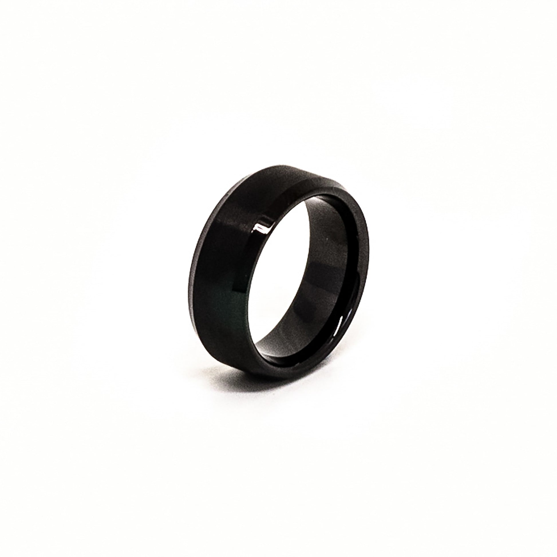 The Stainless Steel Black Bezel ring by FR | Art Jewellery, featuring a glossy, polished finish, stands upright against a white background.