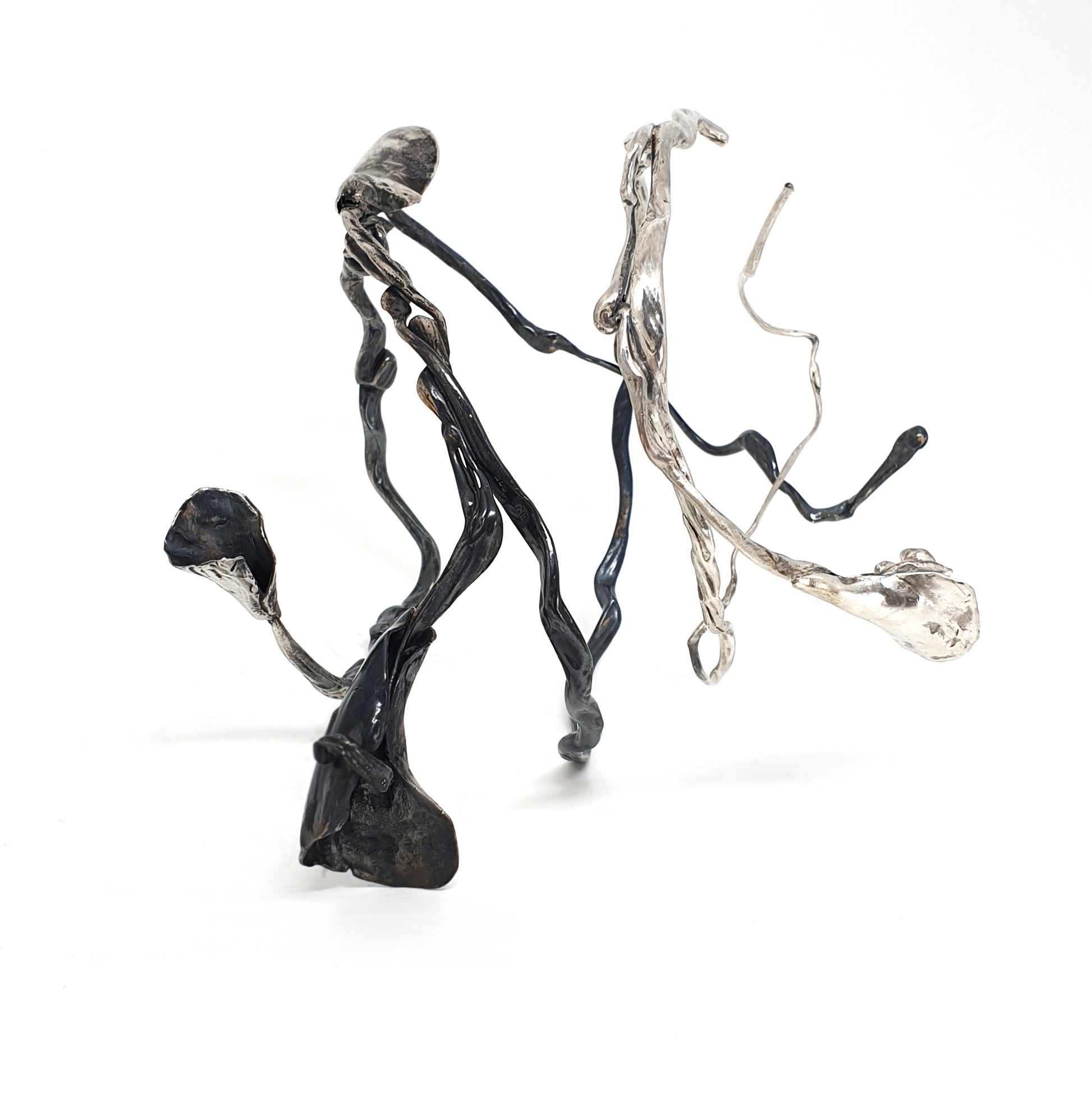 The Seaweed Bangle Sterling Silver by FR | Art Jewellery is an abstract metallic sculpture with twisting, irregular silver and black rods ending in organic, flower-like forms, displayed on a white background.