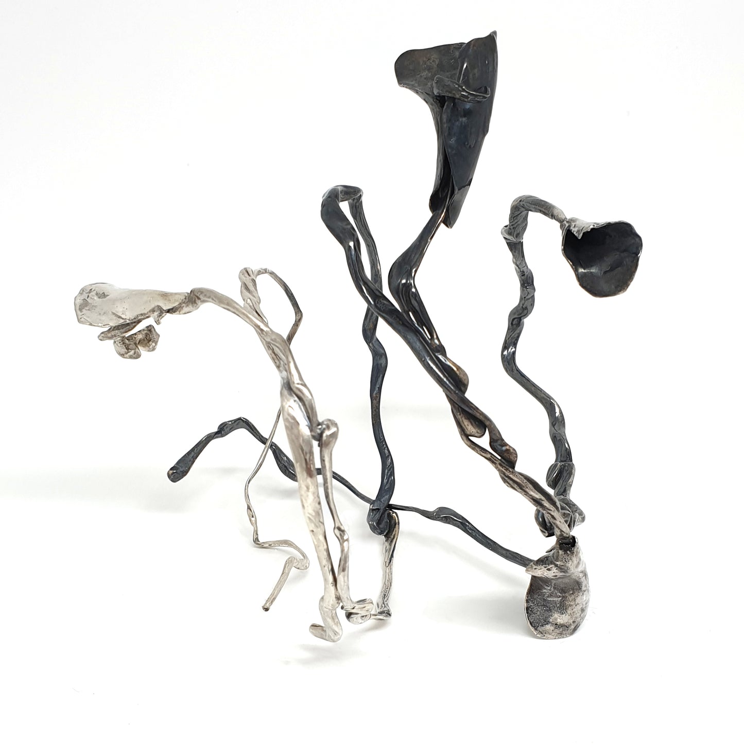 The Seaweed Bangle Sterling Silver by FR | Art Jewellery is an abstract metallic sculpture with twisting, irregular silver and black rods ending in organic, flower-like forms, displayed on a white background.