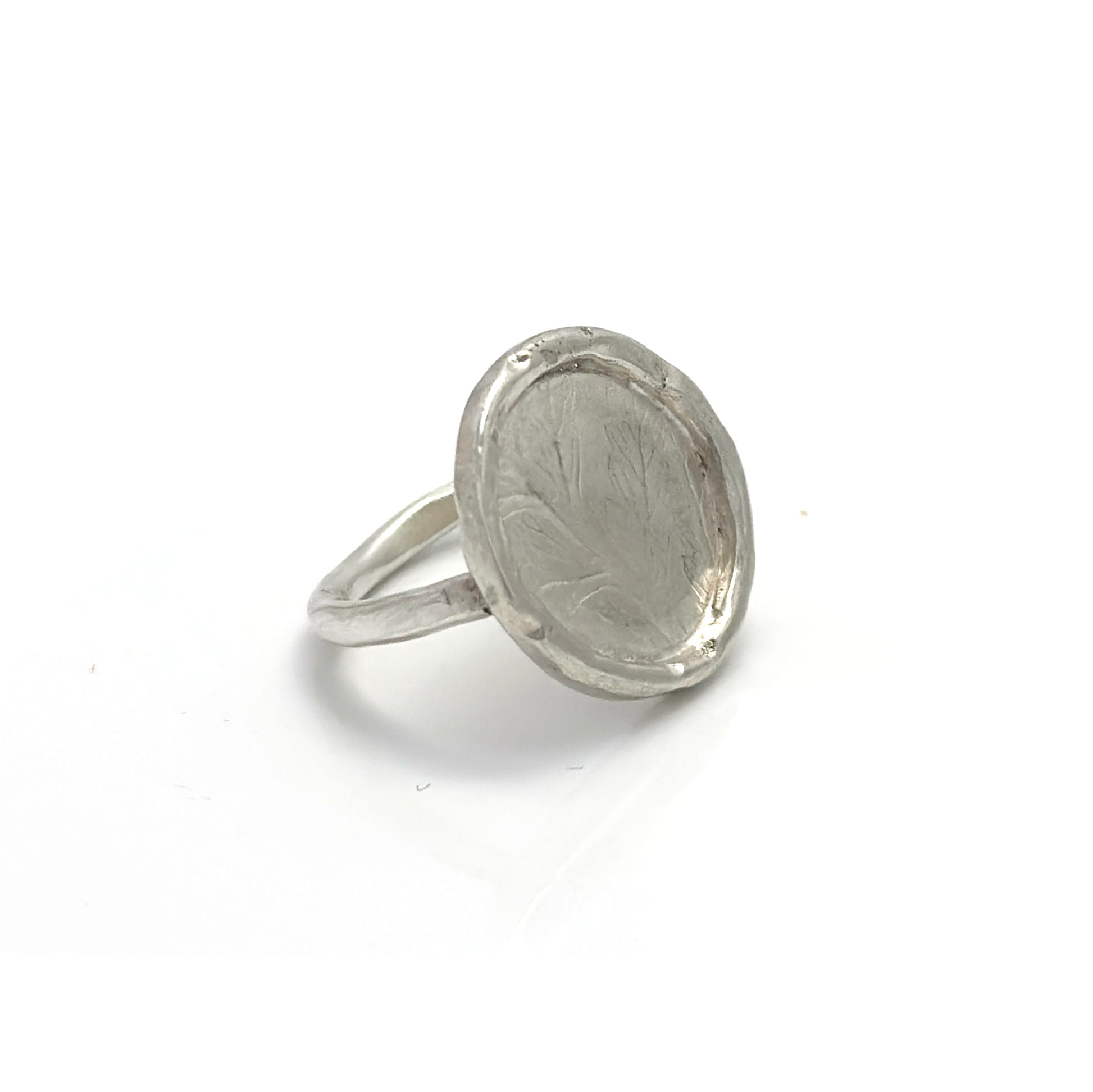The Silver Leaf Impression Ring – Sterling Silver by FR | Art Jewellery features a wide, round flat top with subtle, nature-inspired engravings and a raised edge, beautifully showcased against a white background.