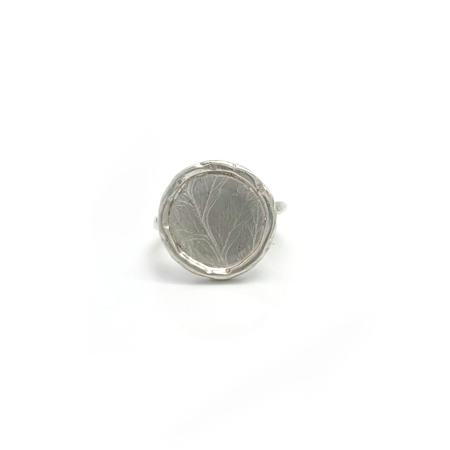 The Silver Leaf Impression Ring – Sterling Silver by FR | Art Jewellery features a wide, round flat top with subtle, nature-inspired engravings and a raised edge, beautifully showcased against a white background.