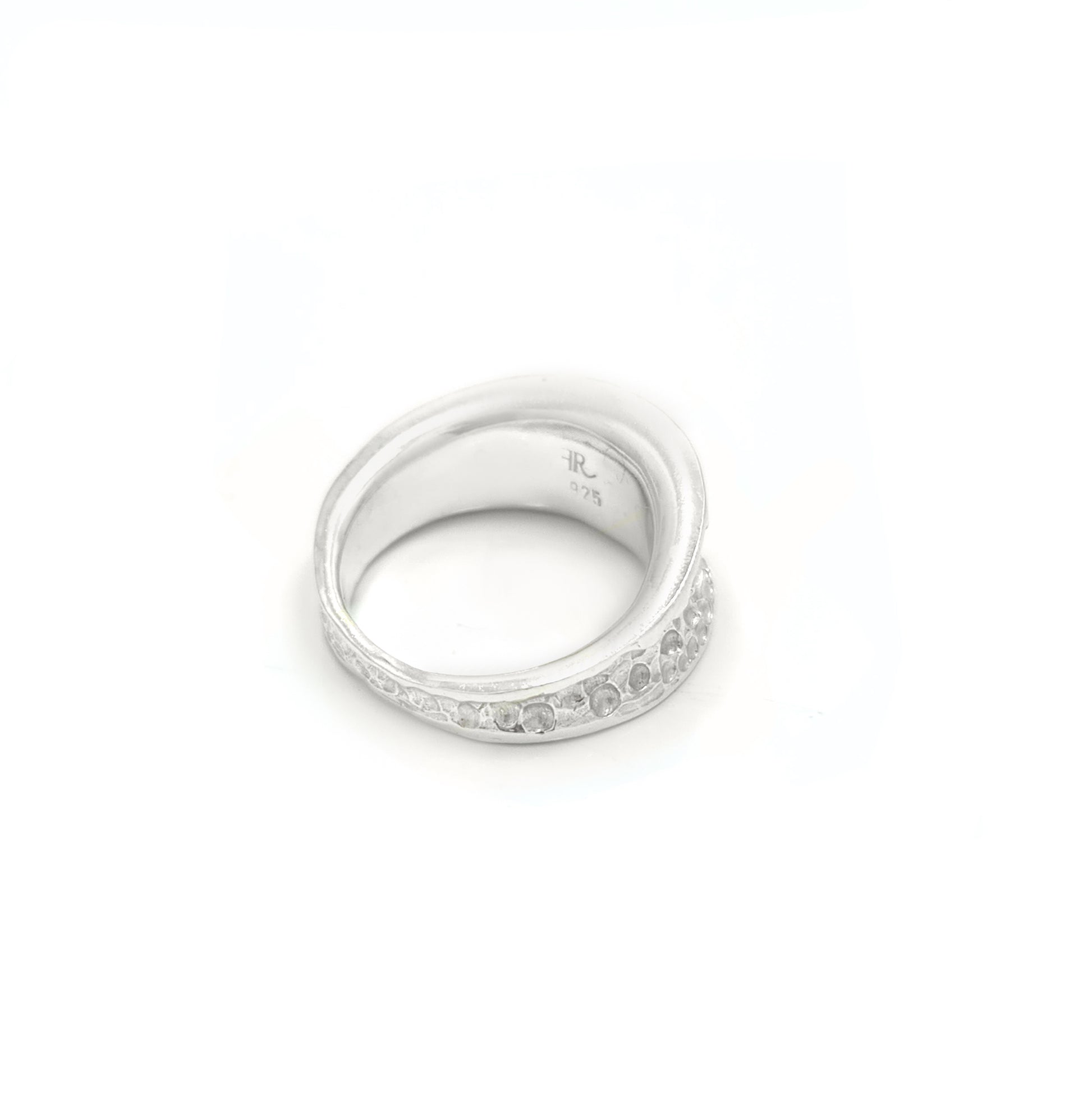 The Spot Ring by FR | Art Jewellery is a silver accessory with a wide band, showcasing a textured, hammered surface design. It boasts a shiny, polished finish and is displayed against a plain white background, exemplifying exquisite handmade jewellery craftsmanship.