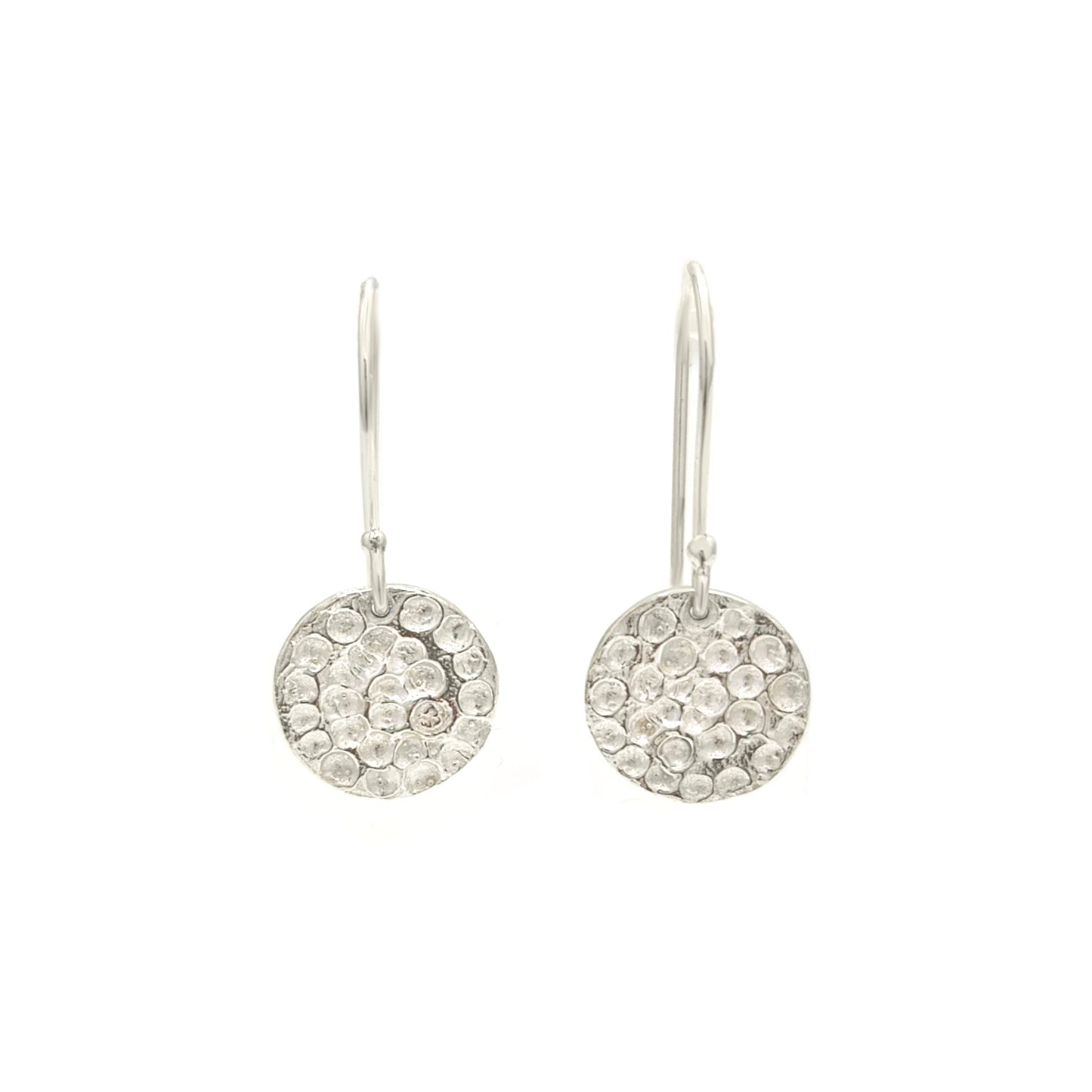 The Spot Earrings by FR | Art Jewellery are a pair of delicate sterling silver drop earrings, featuring textured circular discs hanging from simple hooks. The discs boast a hammered finish that adds a touch of sparkle, perfectly showcasing the elegance of handmade jewelry. These exquisite earrings are displayed against a plain white background.