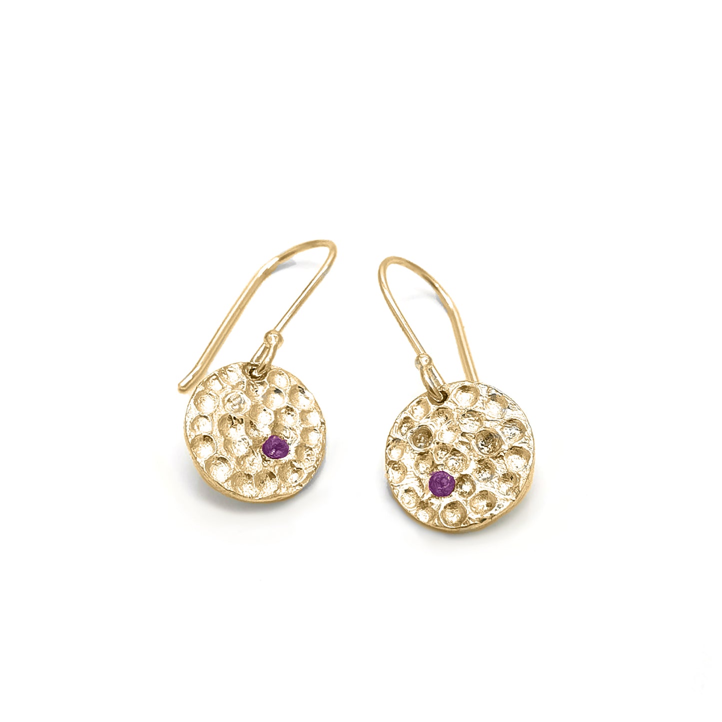 Introducing the Spot of Light Earrings by FR | Art Jewellery, a stunning pair of gold-plated dangle earrings featuring textured circular designs. Each earring showcases a small purple stone at its center, adding a touch of elegance. The simple hook fastening ensures ease of wear, making these artisanal pieces truly embody the sophistication of handmade jewellery.