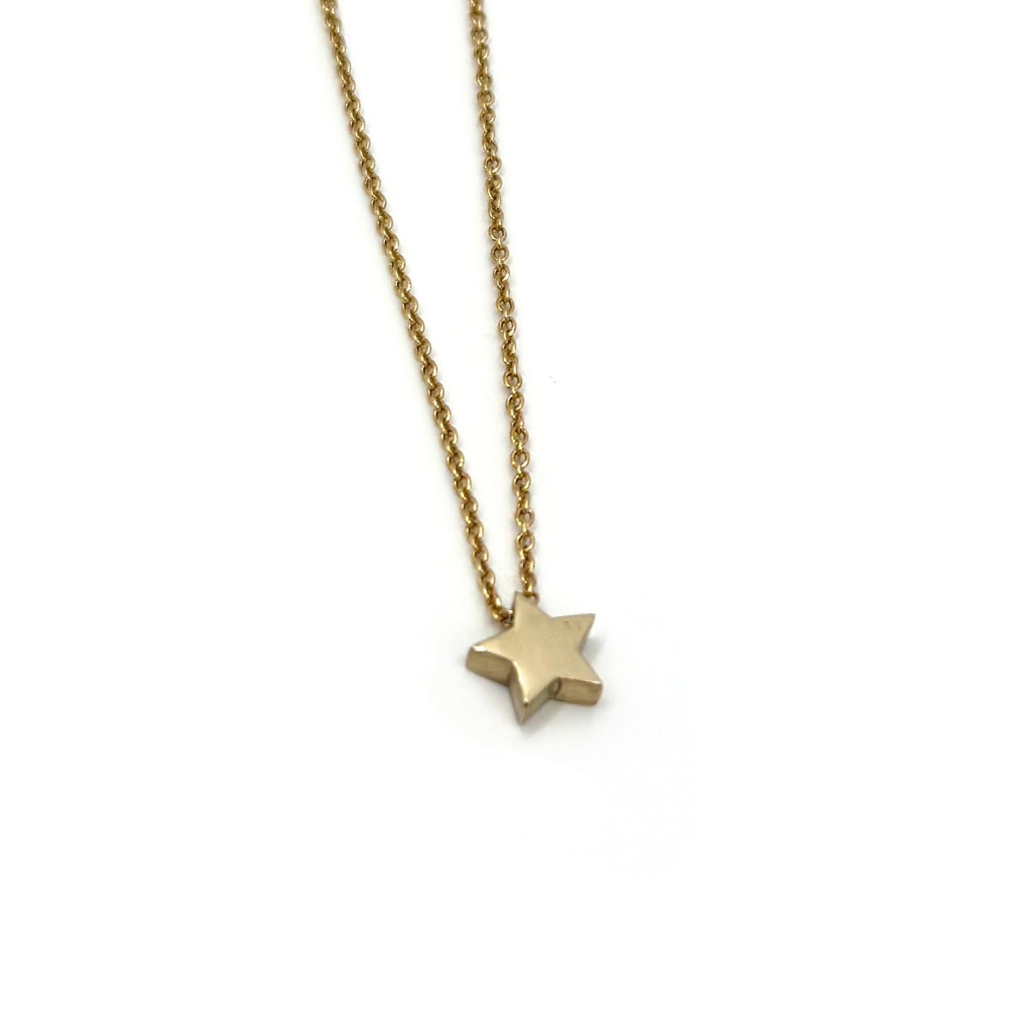 Introducing the Star Necklace by FR | Art Jewellery: This delicate gold chain necklace showcases a small, polished gold star pendant. The chain boasts a simple, elegant design with tightly linked segments. As a handmade piece of jewellery, it exudes minimalist charm with the star pendant beautifully centered against a plain white background.