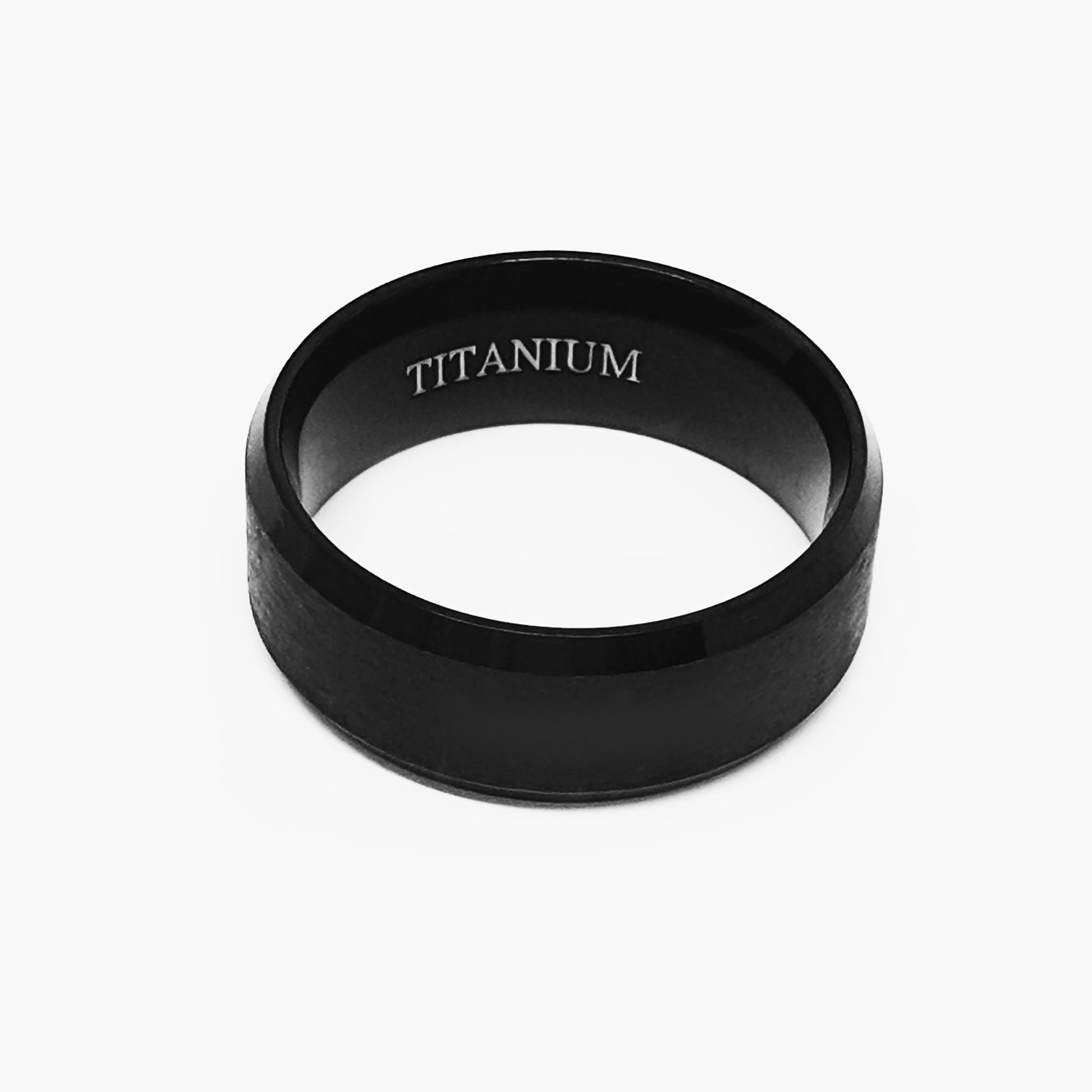 The Titanium Black Bezel Ring by FR | Art Jewellery is displayed on a white background. This comfort-fit band features a smooth black matte finish and "TITANIUM" engraved on its inner surface.