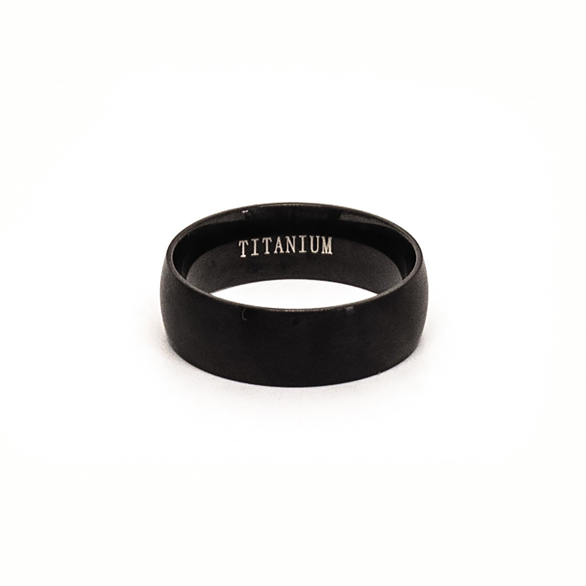 The Titanium Black Ring by FR | Art Jewellery is a comfort-fit titanium band with a black matte finish, shown upright on a white background and engraved with "TITANIUM" inside.