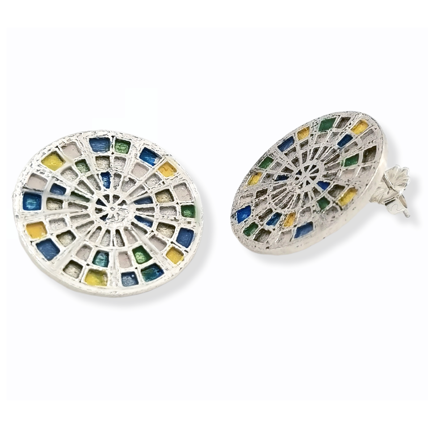 Introducing the Talis Earrings by FR | Art Jewellery, a stunning pair of round stud earrings designed with a stained glass window motif. These intricate pieces feature colored segments in shades of blue, green, and yellow, all beautifully set in silver-tone metal. Handmade to perfection, one earring is displayed front-on while the other is subtly angled.