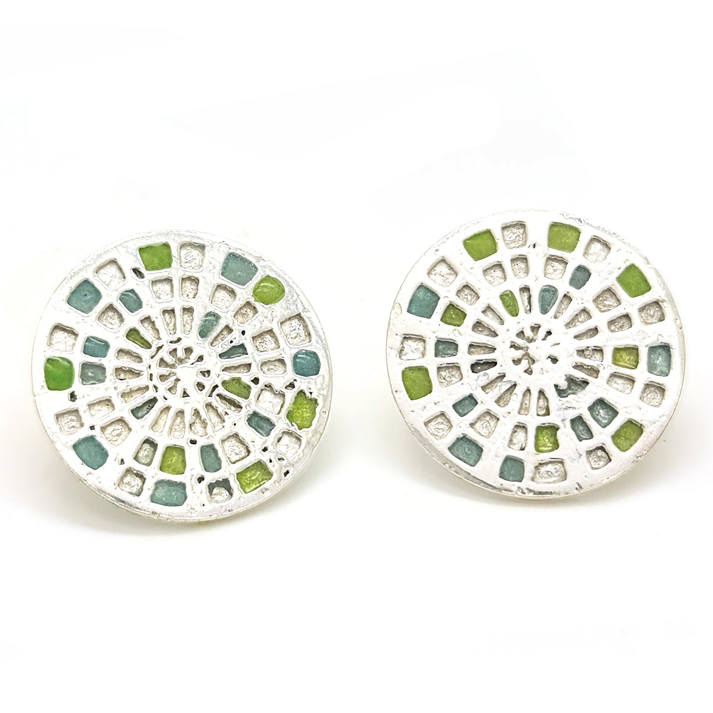 Introducing the Talis Earrings by FR | Art Jewellery, a stunning pair of round stud earrings designed with a stained glass window motif. These intricate pieces feature colored segments in shades of blue, green, and yellow, all beautifully set in silver-tone metal. Handmade to perfection, one earring is displayed front-on while the other is subtly angled.