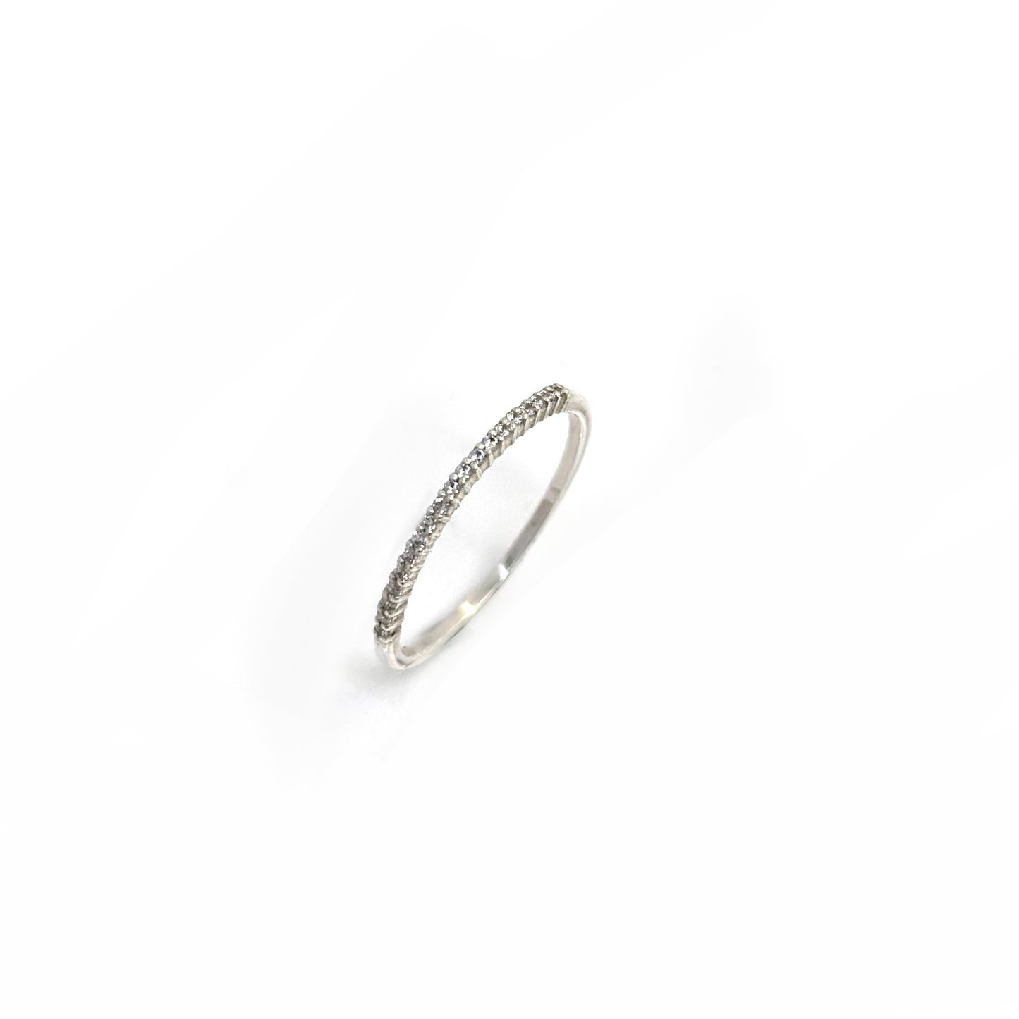 The Tiny Eter Ring (Quartz) by FR | Art Jewellery features a delicate silver pavé band with small clear stones along the top half, ideal for stacking or as elegant daily wear, shown on a white background.