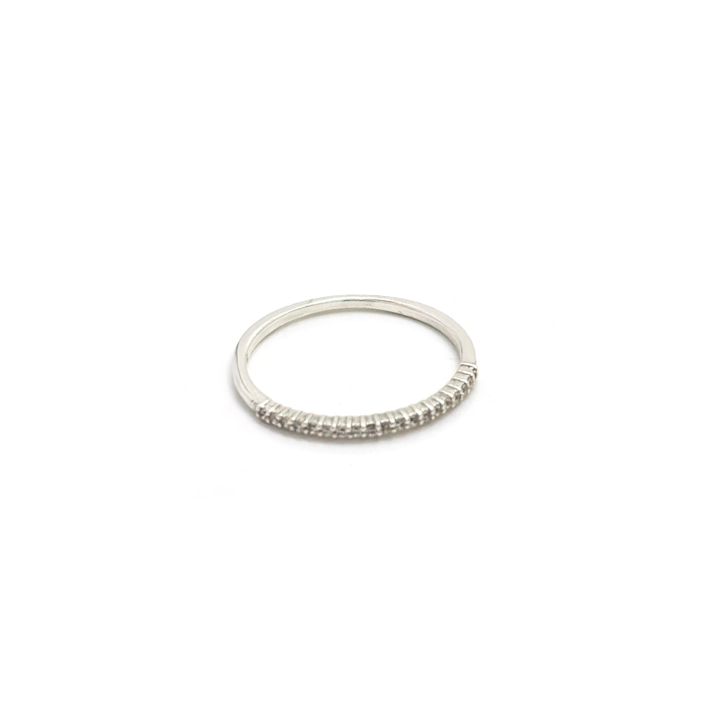 The Tiny Eter Ring (Quartz) by FR | Art Jewellery features a delicate silver pavé band with small clear stones along the top half, ideal for stacking or as elegant daily wear, shown on a white background.