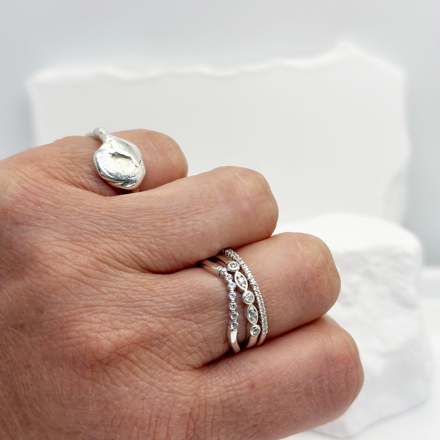 The Tiny Wave Ring (Quartz) by FR | Art Jewellery features a delicate silver curved band with sparkling diamonds set along the top half, ideal for personalised stackable ring collections.