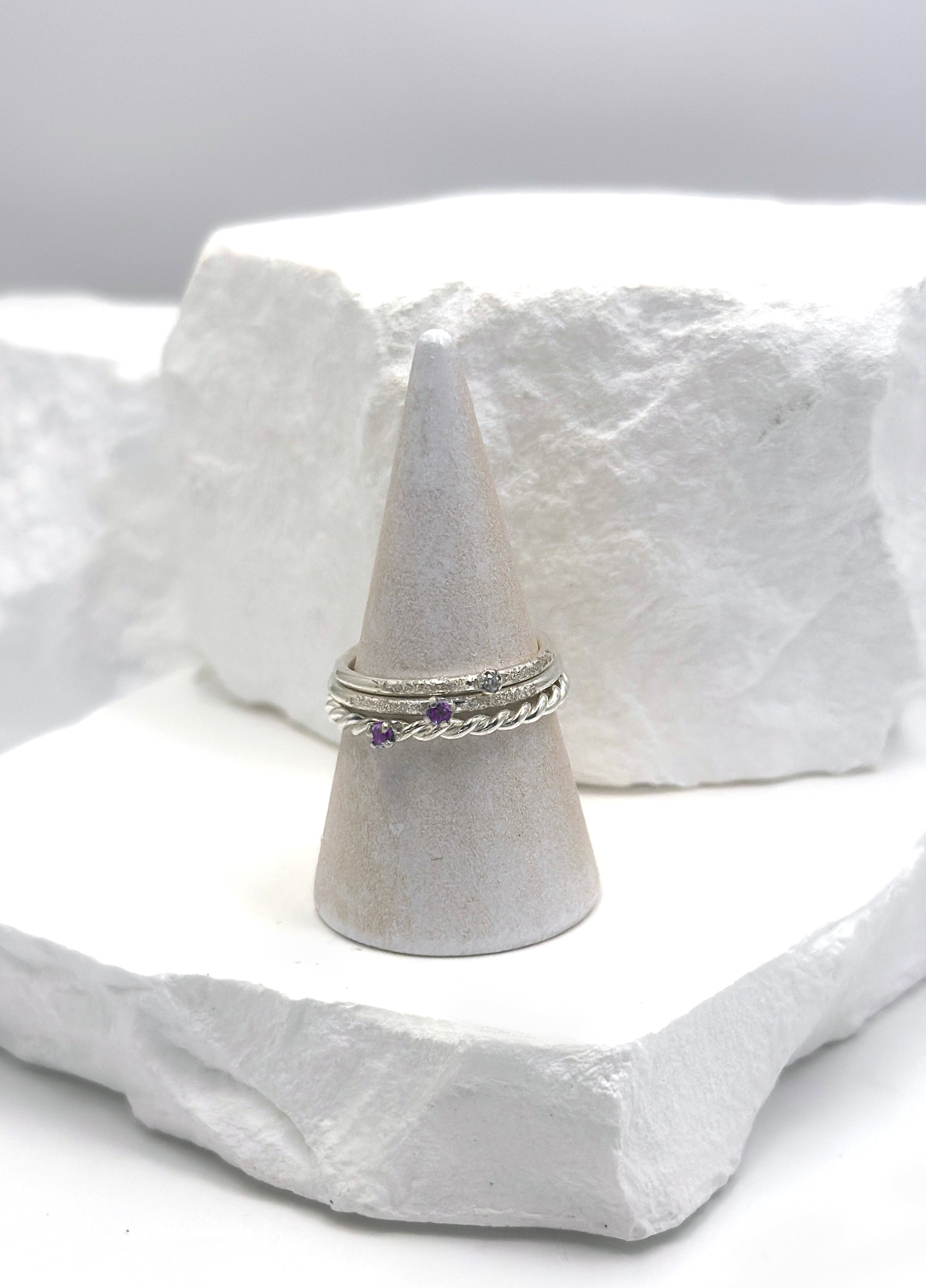 The Tinytoo Sterling Silver twisted Ring with Amethyst Gemstone by FR | Art Jewellery features a minimalist design—perfect for everyday elegance and beautifully displayed on a white background.