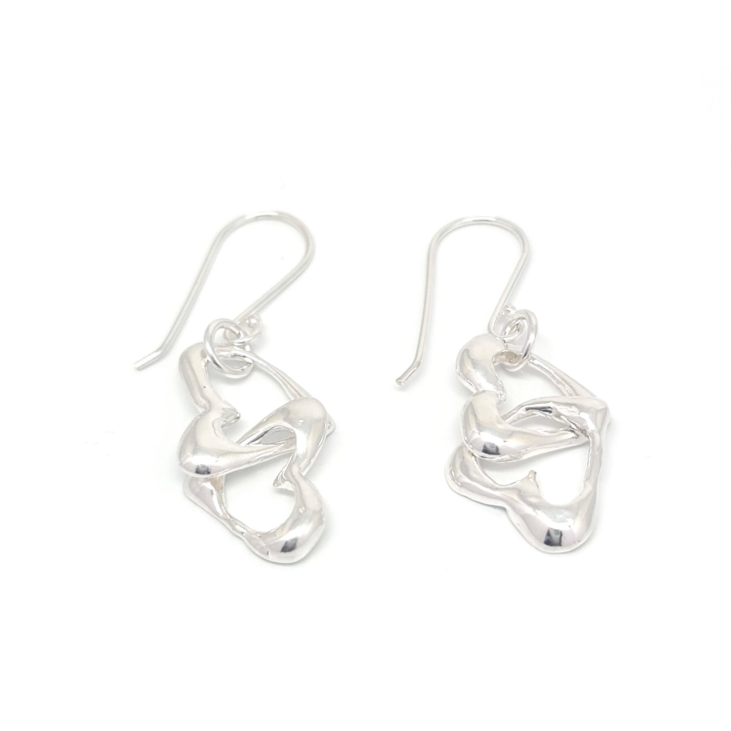 Introducing the Together Love Earrings by FR | Art Jewellery: a pair of silver dangle earrings showcasing artistic, intertwined metal shapes. The design features smooth, flowing curves that create an abstract, modern look. Each earring hangs from a simple hook and boasts a polished, shiny finish. Elevate any outfit with this exquisite piece of handmade jewellery.