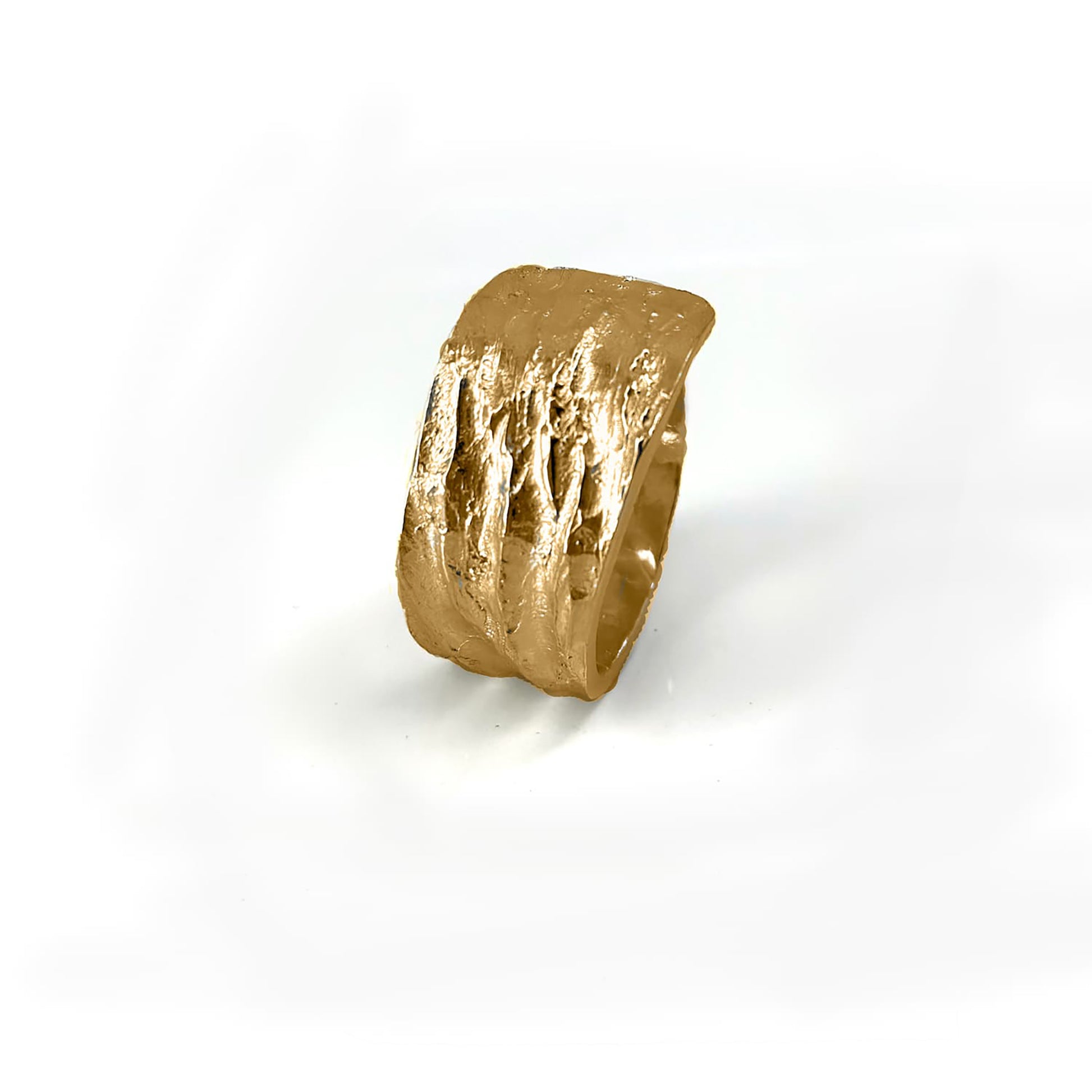 The Tribu Ring from FR | Art Jewellery is showcased against a pristine white background. This handmade piece of jewellery boasts a textured gold finish and a wide band, featuring an innovative design with part of the band overlapping to create a layered effect on one side. Custom orders are available to match gold-plated earrings for a cohesive set.