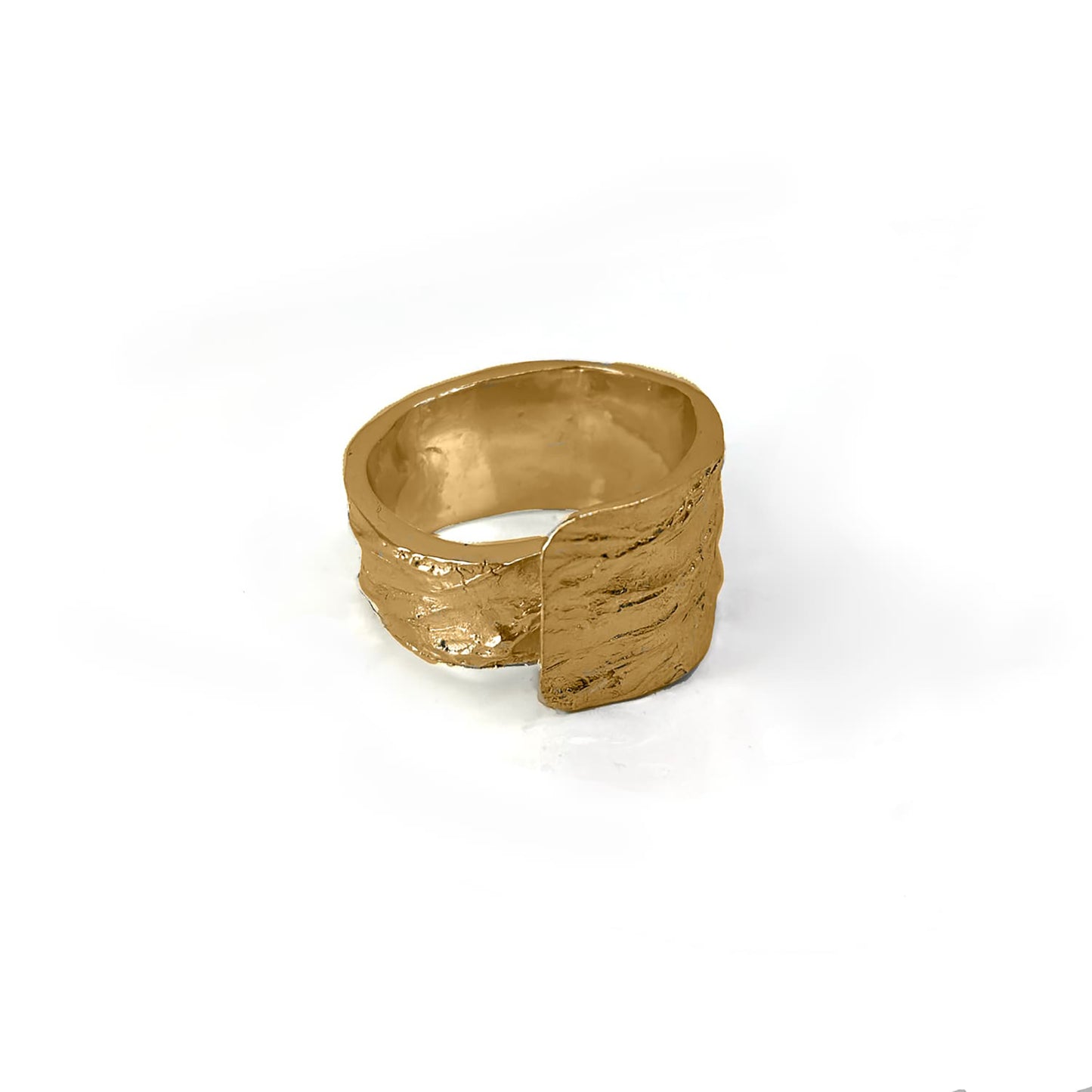 The Tribu Ring from FR | Art Jewellery is showcased against a pristine white background. This handmade piece of jewellery boasts a textured gold finish and a wide band, featuring an innovative design with part of the band overlapping to create a layered effect on one side. Custom orders are available to match gold-plated earrings for a cohesive set.