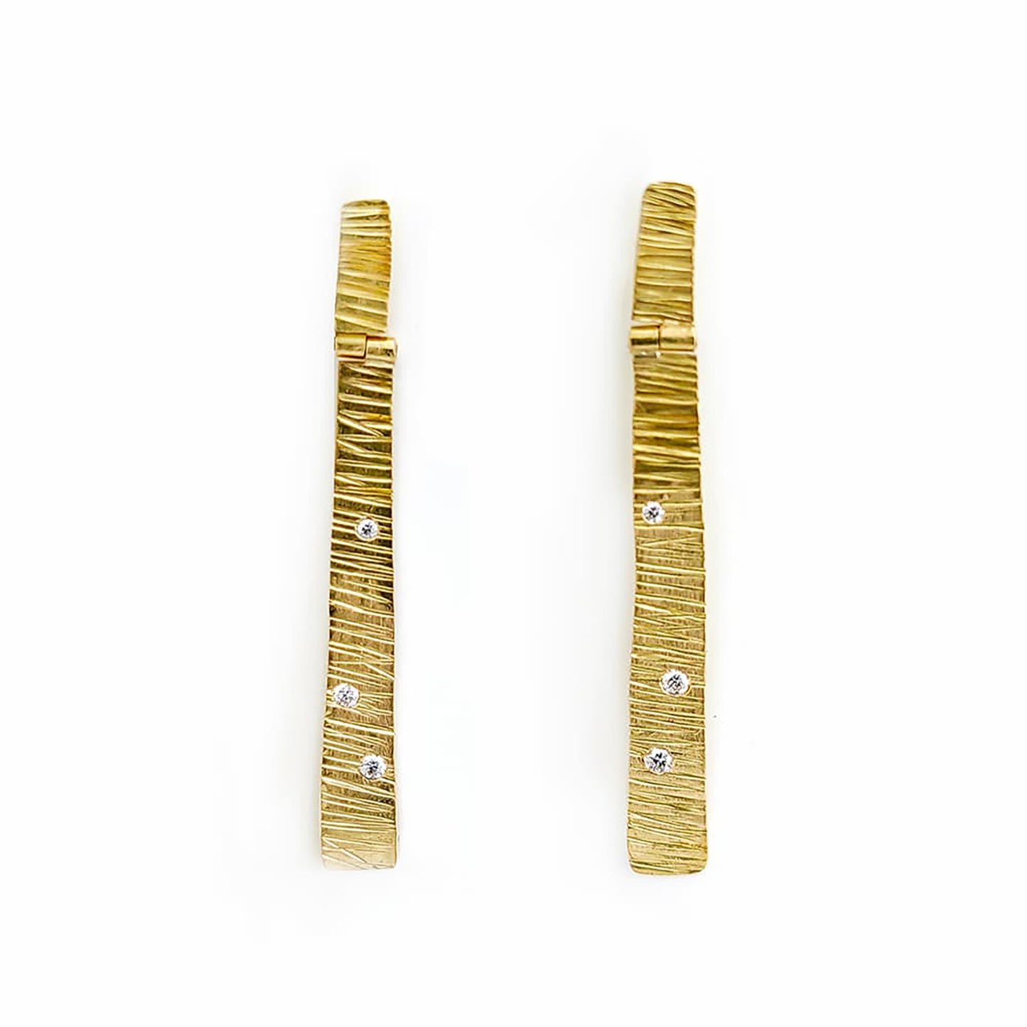 Introducing the Tribu Gold Diamonds Earrings by FR | Art Jewellery, a stunning pair of long, rectangular earrings with a luxurious gold-plated finish and a textured surface. Adorned with small, sparkling rhinestone accents, these handmade pieces are beautifully displayed on a plain white background and are an excellent choice for custom-made orders.