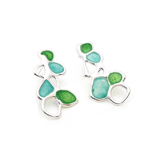 The Vitro Blue and Green Earrings by FR | Art Jewellery showcase an abstract design with green and turquoise enamel accents. These sterling silver earrings feature an organic, flowing shape, creating an artistic and modern look against a white background, making them perfect for your Colour Collection.