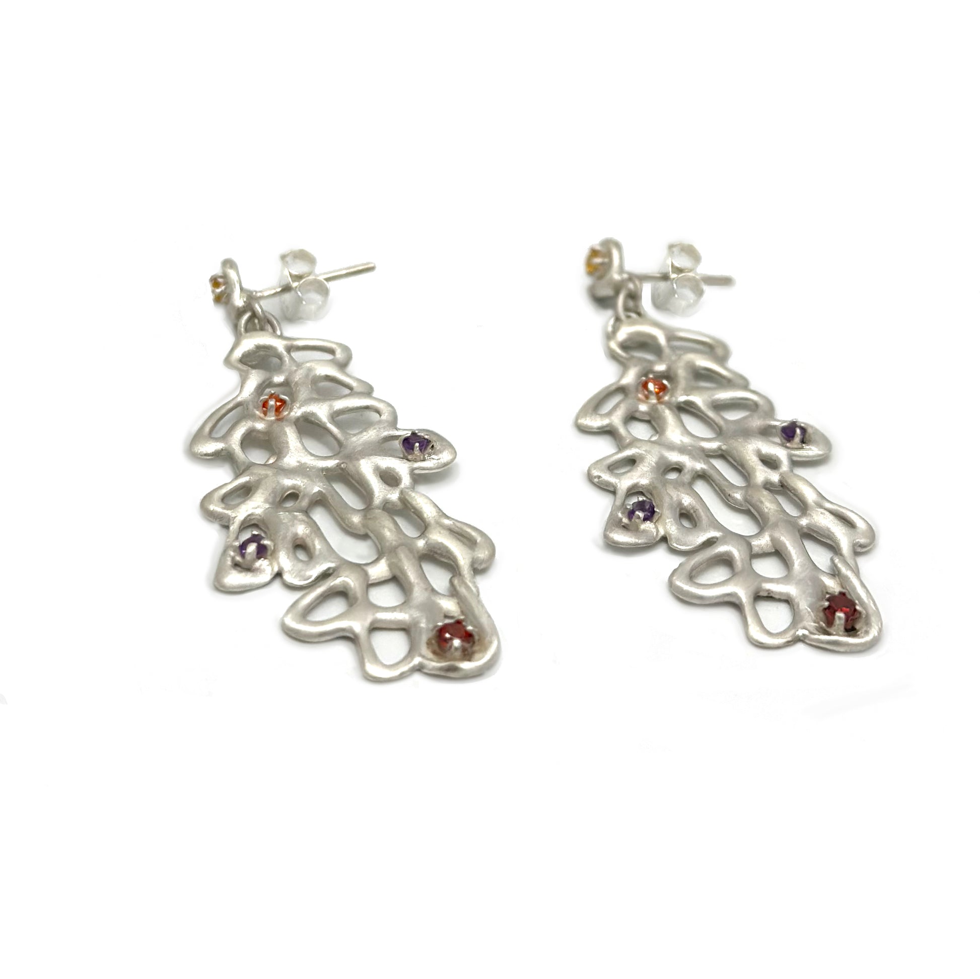 The Raceme Earrings by FR | Art Jewellery showcase an elaborate sterling silver design that mimics a branching, web-like structure. Each earring is embellished with small, vibrant gemstones in shades of orange, red, yellow, and purple. Part of the Blossom Series, these earrings have a delicate and artistic allure.