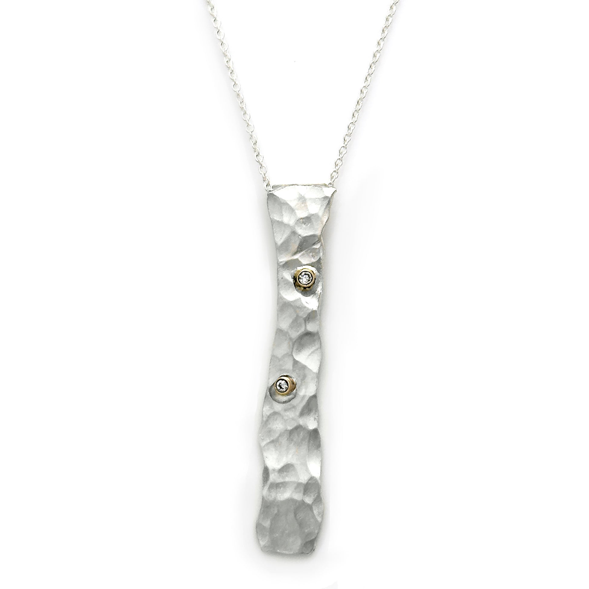 The "Shooting Star Necklace" by FR | Art Jewellery features a silver, rectangular pendant with a hammered texture and two small, sparkling gemstones. This pendant is suspended on a fine silver chain and showcases an uneven, organic shape that adds an artisanal touch to this handmade jewellery design. The background is plain white.