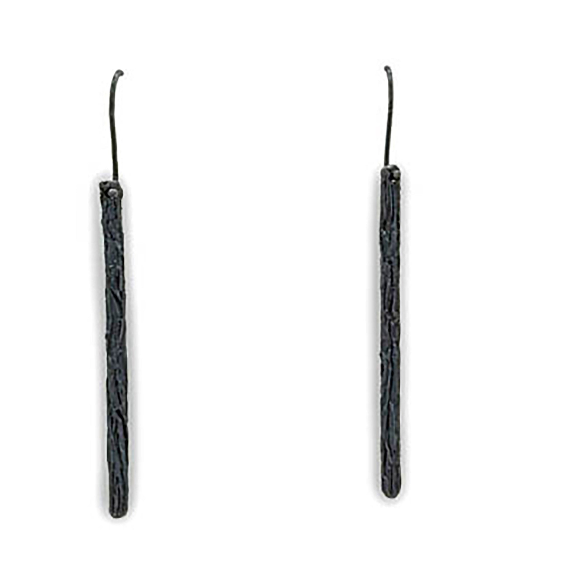 Introducing the Succulent Garden Earrings Oxidized by FR | Art Jewellery: a pair of long, slender, black dangle earrings with a slightly textured surface. These handmade earrings feature simple hooks for attachment and embody a minimalist and modern aesthetic, making them ideal for custom-made orders.